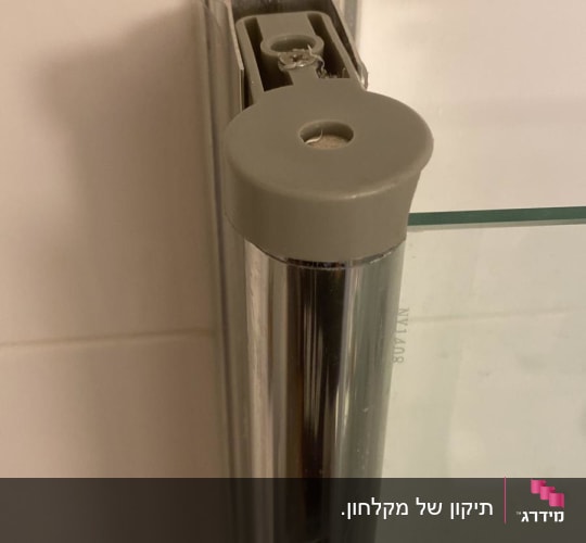 חלק ממסגרת זכוכית של מקלחון עם מחבר מתכת